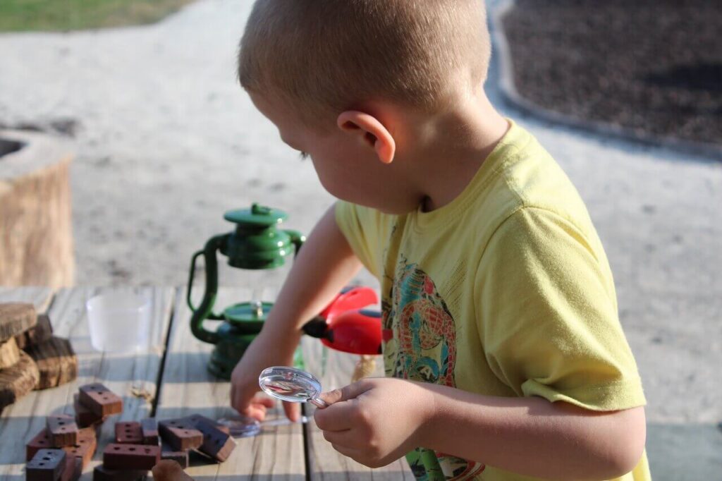 Imagen de un niño jugando con instrumentos científicos en el exterior